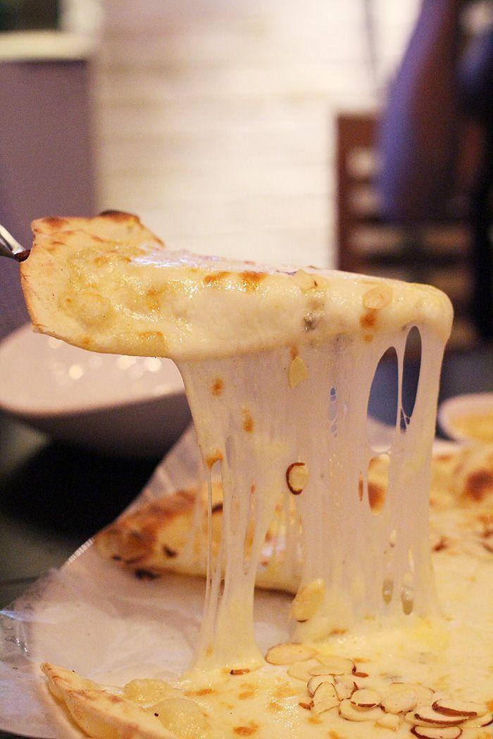 Snapshot of oozing cheese on a slice of Gorgonzola pizza at Hwa Tteok, showcasing a gooey and cheesy perfection.